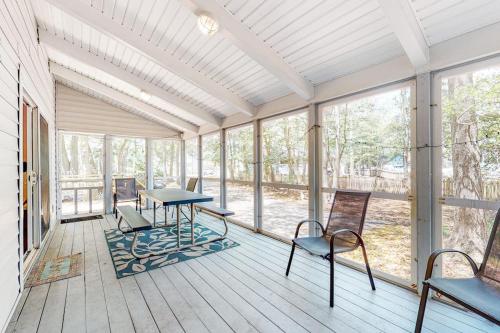 a screened in porch with a table and chairs at Bethany West - 609 Brookview in Bethany Beach