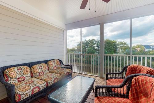 a screened in porch with a couch and two chairs at Bear Trap Dunes - 58D October Glory in Ocean View