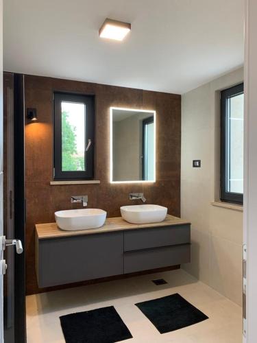 a bathroom with two sinks and two mirrors at ISTRIAN vibeS in Drenje