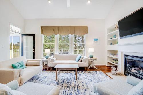 a living room with white furniture and a fireplace at Bear Trap Dunes --- 83F October Glory Dunes in Ocean View