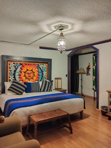 a bedroom with a large bed with a painting on the wall at Hotel Rincon de Josefa in Pátzcuaro