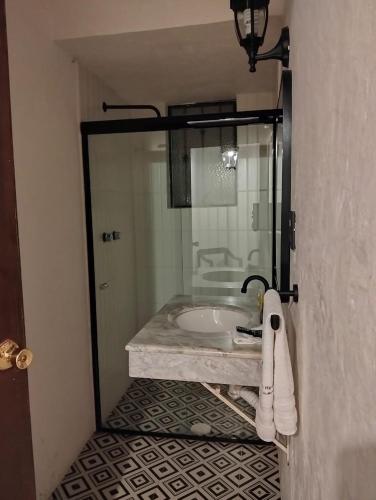 a bathroom with a sink and a glass shower at Hotel Rincon de Josefa in Pátzcuaro