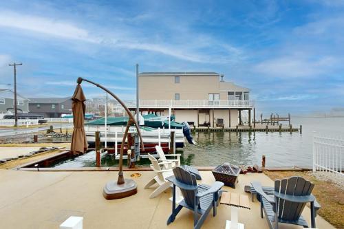 a house on a dock with chairs and a boat at West Fenwick --- 39110 Van Buren Ave in Selbyville