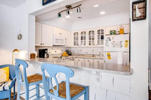 a kitchen with white cabinets and blue bar stools at Sea Colony - 903 Singles Ct in Bethany Beach