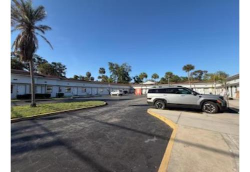 a white van parked in a parking lot next to a building at Regency Inn Daytona Beach Near Airport in Daytona Beach