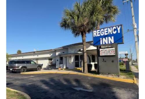 a freeway inn with a palm tree in a parking lot at Regency Inn Daytona Beach Near Airport in Daytona Beach