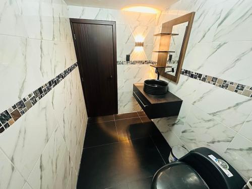 a bathroom with a toilet and a sink and a mirror at BaseCotopaxi Mini depart 5p free parking in Latacunga