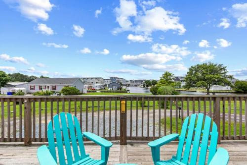 two blue chairs sitting on a deck with a fence at Fenwick Island -- 28 High Tide in Fenwick Island