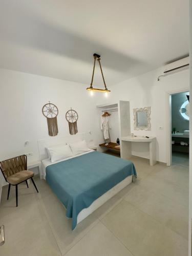 a bedroom with a blue bed and a chair at Villa Echedra in Vlychada