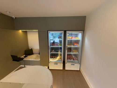 a room with an open refrigerator and a bed at Premium Office-My Stay 09 in Brasília