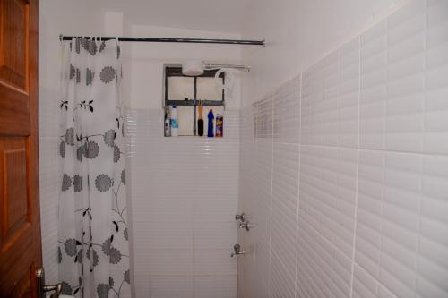 a bathroom with a shower with a shower curtain at Parma Staycation in Rungiri