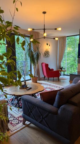 a living room with a couch and a red chair at Spa Villa Smetovi with Jacuzzi & Sauna in Zenica