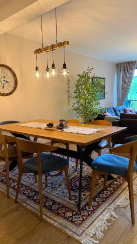 a dining room with a wooden table and chairs at Spa Villa Smetovi with Jacuzzi & Sauna in Zenica