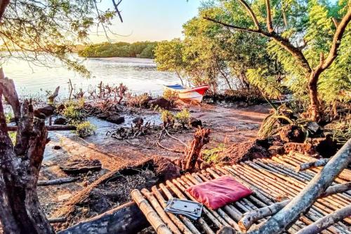 a picnic table on the shore of a river at Poneloya Budget Accomodations in León