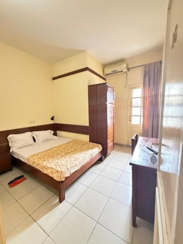 Un pat sau paturi într-o cameră la Infinity Hôtel