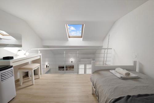 a white bedroom with a bed and a desk at Apartmani Rialto in Kakma