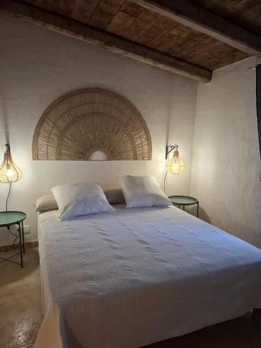 a bedroom with a large white bed with two tables at Casa Olea in Sartène