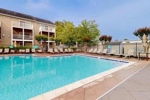 a large swimming pool with chairs and a building at Rehoboth Crossing --- 19913 Ames Drive #106 in Rehoboth Beach