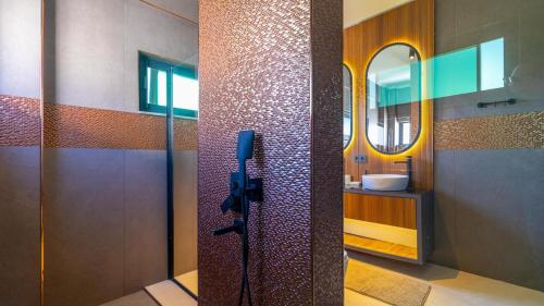 a bathroom with a shower with a sink and a mirror at Villa Marcy in Belek