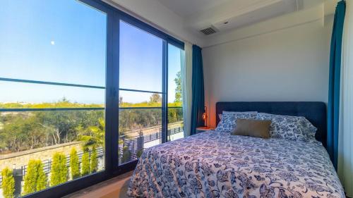 a bedroom with a bed and a large window at Villa Marcy in Belek