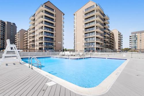 a large swimming pool with two tall apartment buildings at Sea Colony - 4003 Volley in Bethany Beach