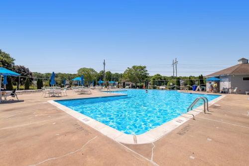a swimming pool at a resort with chairs and umbrellas at Bethany Meadows - 2A Briar North in Frankford