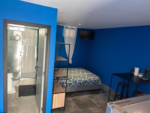 a bedroom with blue walls and a ladder to a bed at Comme à la maison in Villiers-en-Bière