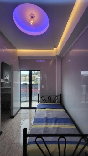 a bed in a room with a blue ceiling at Height 909 Hostal in Juayúa