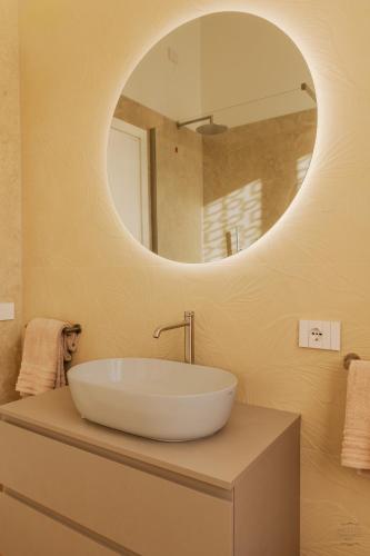 a bathroom with a large white sink and a mirror at Orefici's Home in Ancona