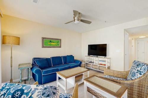 a living room with a blue couch and a tv at Rainbow Cove --- 117 Dagsworthy Ave #B in Dewey Beach