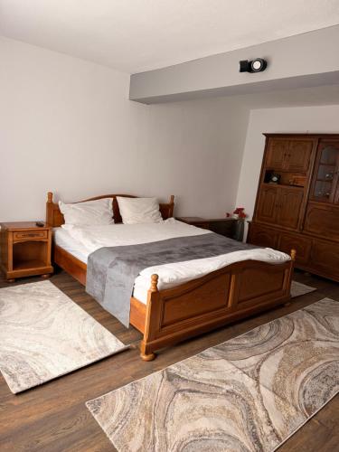 a bedroom with a wooden bed and a dresser at CozyCloud in Poiana Mărului
