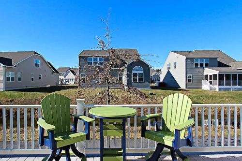 two chairs and a table on a deck with a house at Swann Cove - 36858 Herring in Selbyville
