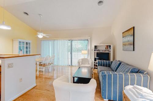 a living room with a blue couch and a kitchen at Sea Colony -- 8901 Timberlake in Bethany Beach