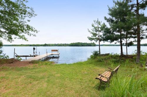 two benches sitting on the shore of a lake at Grand Tomahawk Lodge in Tomahawk