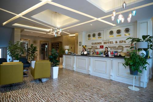 a restaurant with a bar in a room with plants at Garden Hotel & SPA in Bishkek