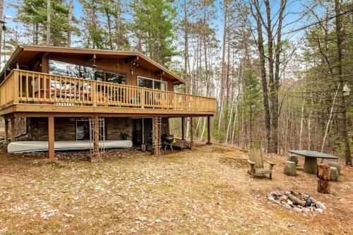 a large house in the woods with a deck at Lakeview North in Lac du Flambeau