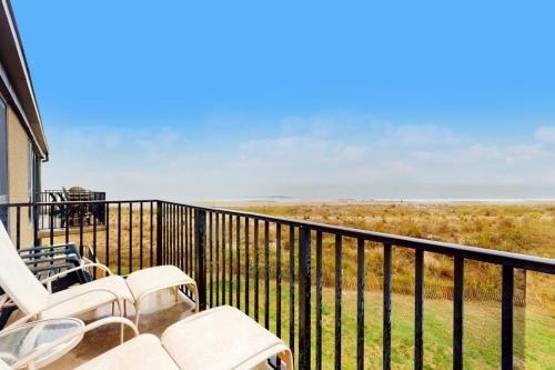 a balcony with white chairs and a view of a field at Sea Colony - 2D Brandywine Garden House Rd in Bethany Beach