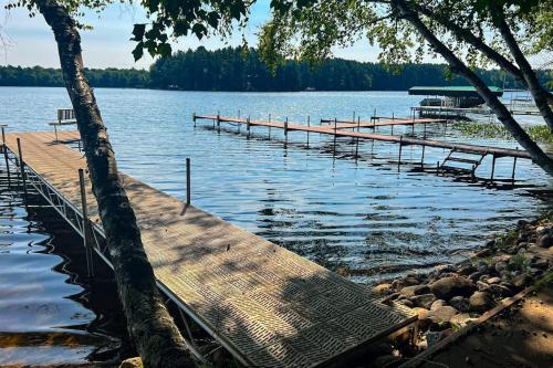 a dock on a lake with a bench on it at Pair-a-Docks Landing in Minocqua