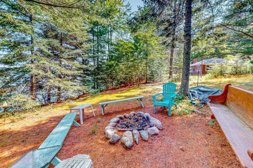 a picnic table and a bench next to a fire pit at Two Sisters Lakeside in Rhinelander