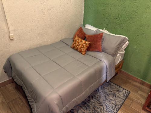 a couch with pillows on it in a room at Hostal el Alebrije in Valle de Bravo