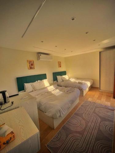 a hotel room with two beds and a table at khofo pyramids view in Cairo