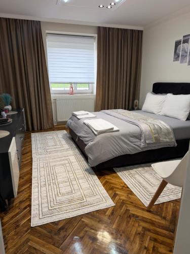 a bedroom with a bed and a desk and a window at Guest house Kula in Kula