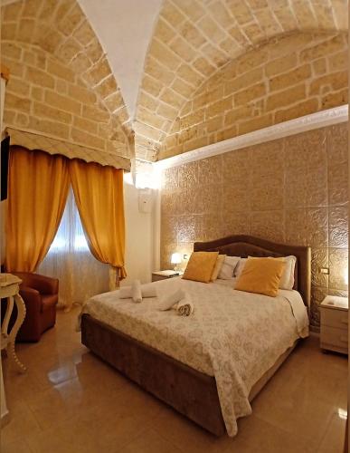 a bedroom with a large bed and a brick wall at B&B I like salento in Uggiano la Chiesa