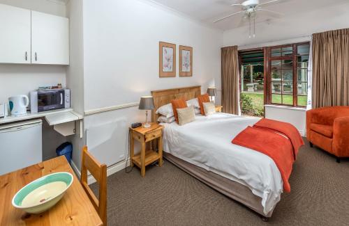 Un dormitorio con una cama grande y una mesa. en Summer Blue Guesthouse, en Port Elizabeth