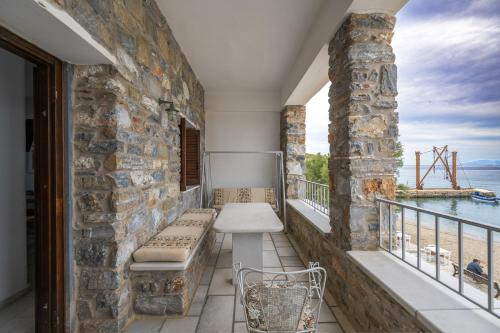 a balcony with a bench and a view of the water at Moutsouna Seaside in Moutsoúna