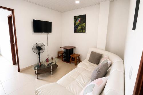 a living room with a white couch and a tv at Acogedor apartamento in Leticia