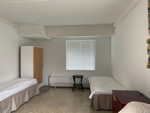 a room with two beds and a window at YKI Room in Oulu