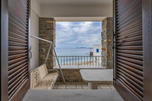 a room with a balcony with a view of the ocean at Moutsouna Seaside in Moutsoúna