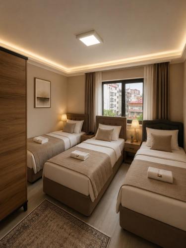 a hotel room with two beds and a window at Trabzon Albayrak Suite in Trabzon