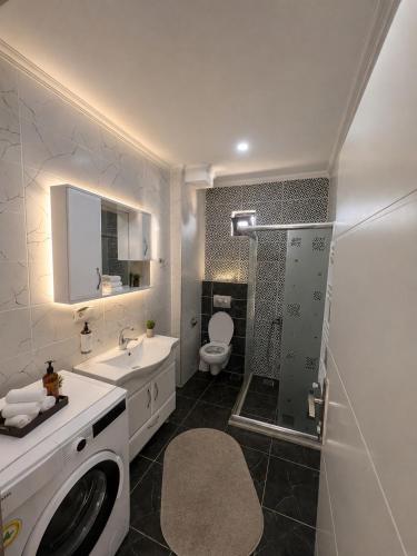 a bathroom with a toilet and a sink and a washing machine at Trabzon Albayrak Suite in Trabzon